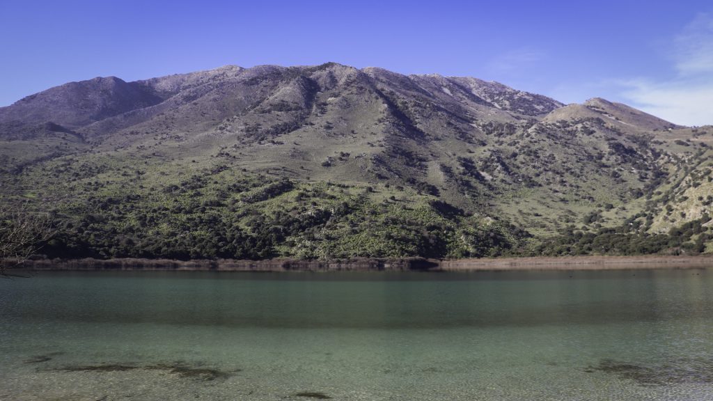Εντυοωσιακή φωτογραφία των Λευκών Ορέων να καθρεφτίζονται στα νερά της λίμνης Κουρνά.